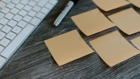 Schreibtisch mit Tastatur und Post-Its