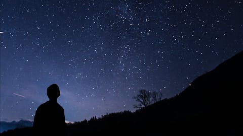 Einsamer wanderer vor spektakulärem Sternenhimmel